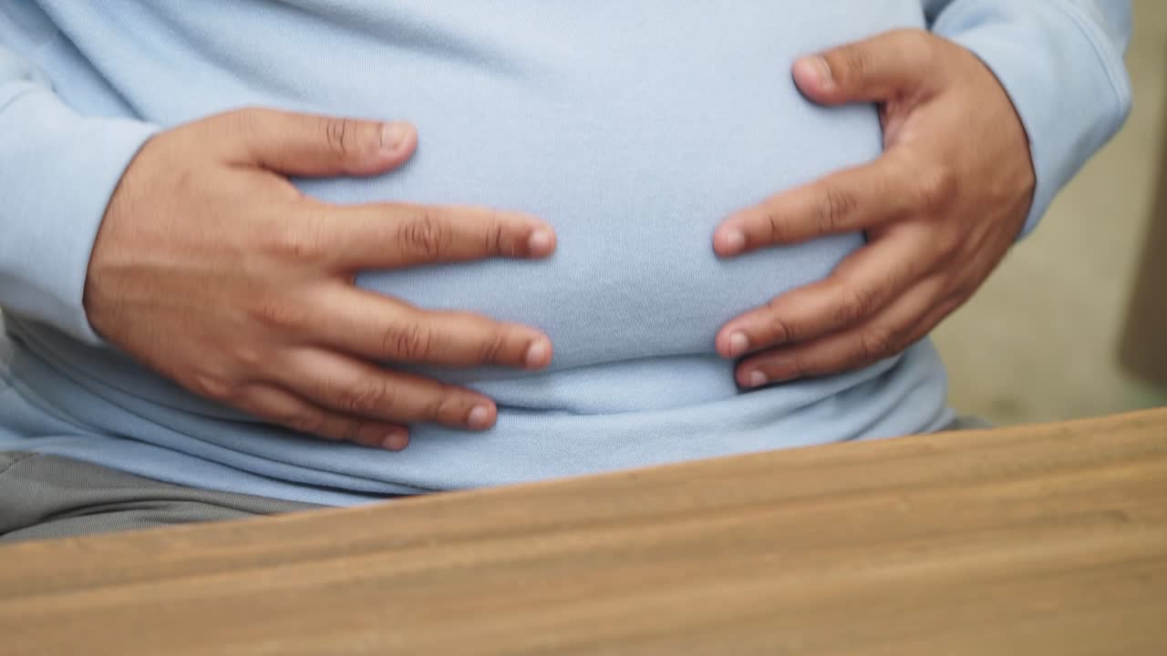 Man holding his swollen belly