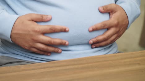 man holding his swollen belly