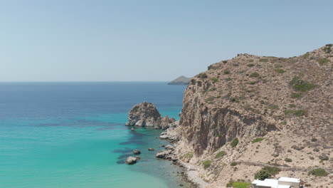 Slow-Aerial-Flight-over-Turquoise-Blue-Ocean-with-Rocky-Cliff-Coast