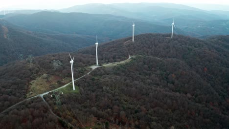 aerial view of wind turbines on a forested mountain ridge, showcasing sustainable energy in a natural setting