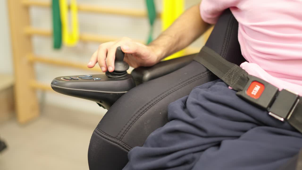 Close-up of Person's Hand Operating Electric Wheelchair Joystick