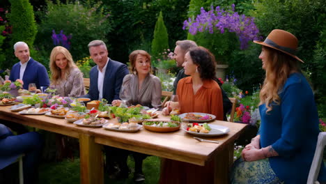 a group of people enjoying an outdoor meal in a beautiful garden