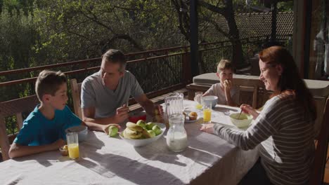 Family-eating-breakfast-together-outdoors