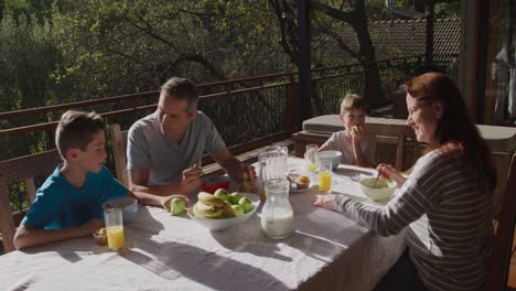 family eating breakfast together outdoors