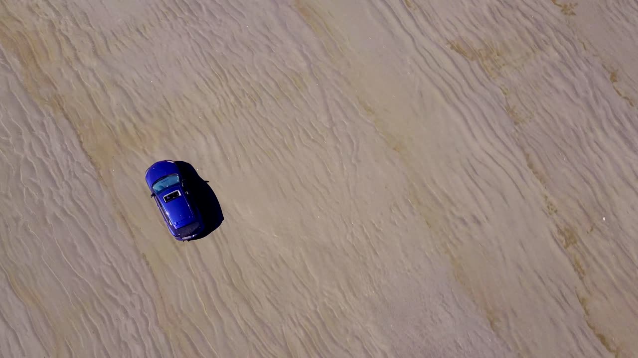 Driving over the brown sand dunes of Washington on a bright summer day - top view