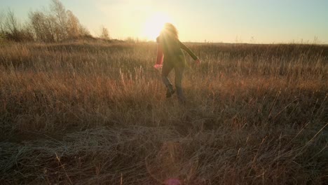 woman running in a field at sunrise/sunset
