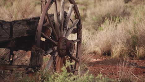 shot-of-a-wheel-of-an-old-covered-wagon-in-a-western-landscape-in-the-early-morning-somewhere-in-the-USA-in-4k