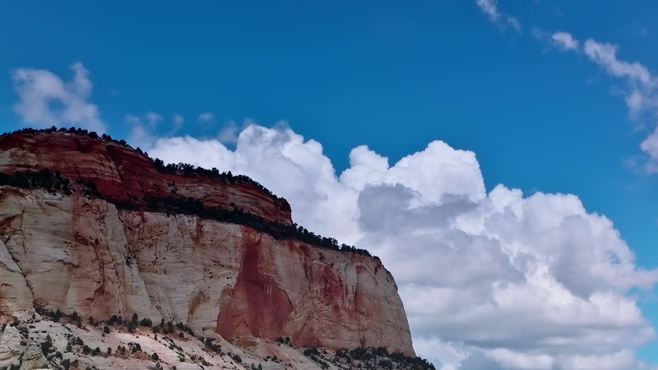Paisaje del Mojave con una formación rocosa roja bajo un cielo azul y nubes.