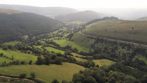 Aerial-view-Horseshoe-pass-lush-scenic-misty-mountain-valley-picturesque-rural-countryside-right-parallax