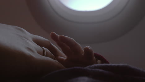 mother and baby hands view in airplane