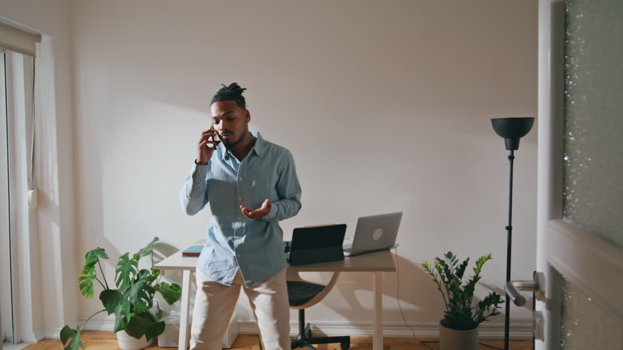 Angry guy talking smartphone home office. Annoyed man arguing having disagree