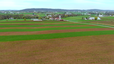 Aerial-flyover-above-rural-countryside-of-Northeastern-America,-lush-green-meadows,-freshly-cultivated-fields,-and-traditional-farms,-spring-in-Lancaster-County,-Pennsylvania