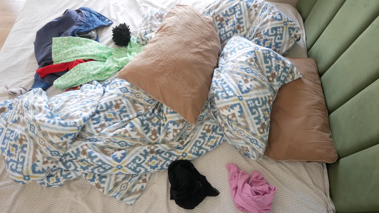 옷이 어져 있는 망진창의 침대