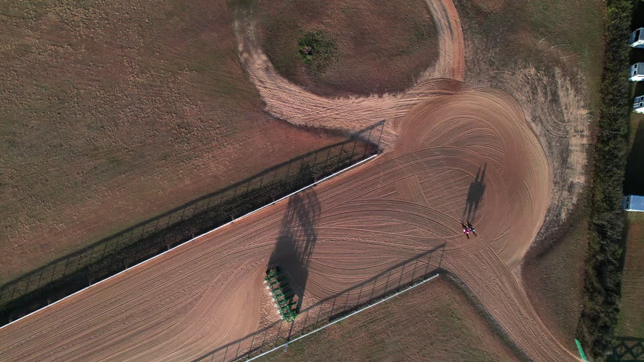 Fantini e cavalli su una pista da corsa, ripresa aerea dall'alto, campagna americana, 4K.