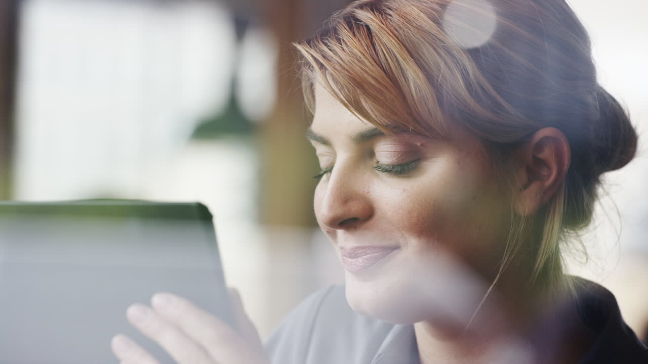 Bella donna che usa un tablet digitale e beve caffè in caffetteria