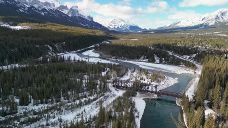Luftschwenk-Auf-Berge-Mit-Fluss-Und-Brücke,-Canmore,-Alberta,-Kanada