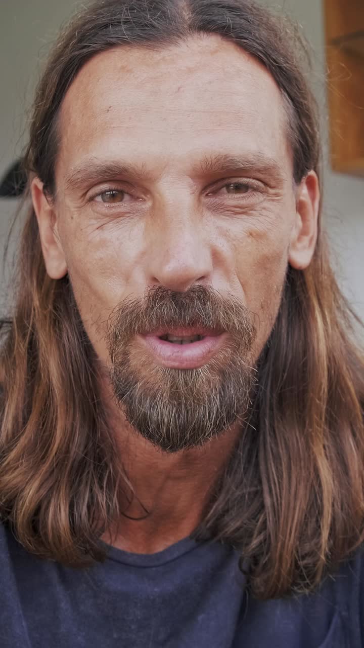 Smiling man with long hair enjoys simple moments of happiness