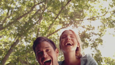 man giving piggyback ride to woman in sunny forest, showcasing health theme with pulsing heart icon
