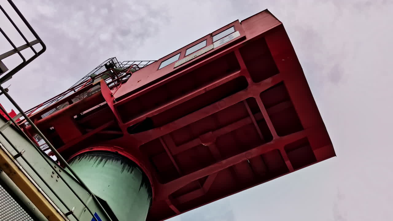 Underside view of industrial crane operator cabin at river port