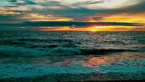 Puesta-De-Sol-De-Hora-Dorada-Con-Tranquilas-Olas-Del-Océano-Rodando-Suavemente-Sobre-La-Playa-En-La-Bahía-De-Looc,-Filipinas