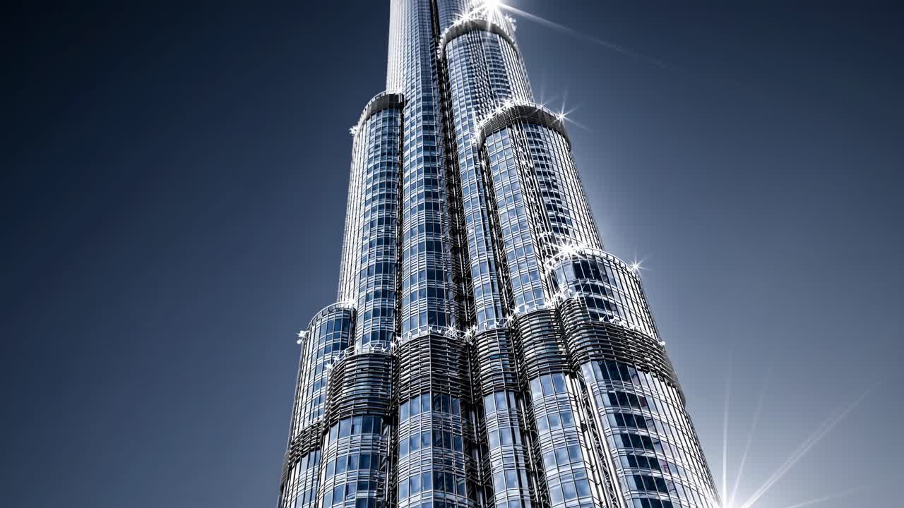 Sunlight gleaming on Burj Khalifa, the tallest building in the world, located in Dubai, United Arab Emirates, creating a stunning contrast against the dark blue sky