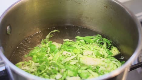 chopped brussel sprouts being blanched in boiling water