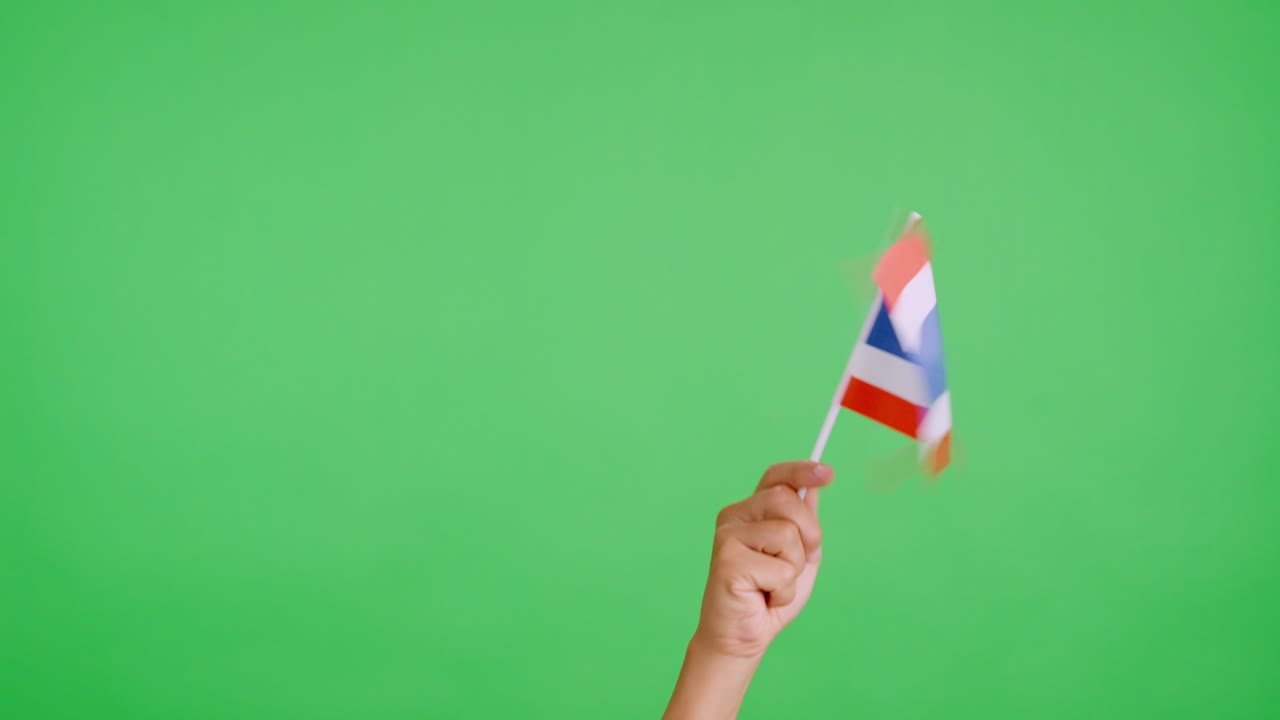 Mano che agita un gagliardetto con la bandiera nazionale thailandese