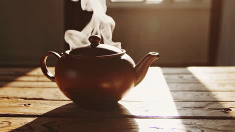 steaming teapot on a wooden table