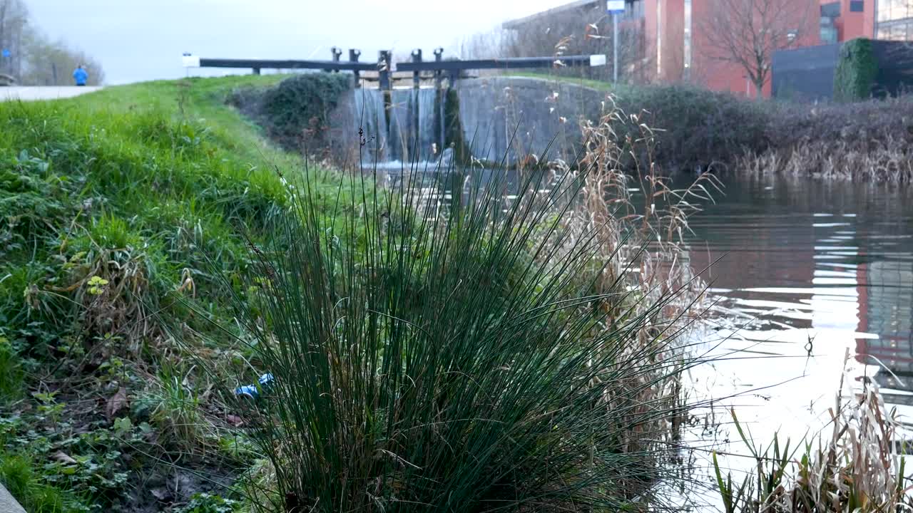 el hombre corre a lo largo del canal junto a la compuerta de agua