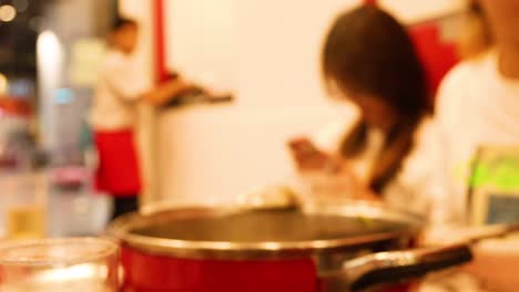 people cooking and using phones in kitchen