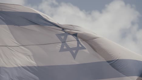 Slow-motion:-Israeli-flag-waves-against-a-blue-sky-with-clouds