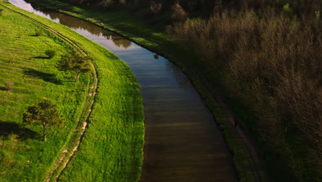 drone flying over the curve of countryside water canal in moldova