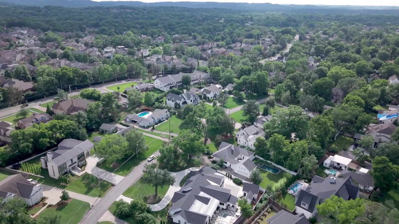 Upscale homes, lush green lawns, and tree-lined streets in Nashville’s exclusive Green Hills neighborhood, a luxury real estate suburb in Tennessee - aerial flyover