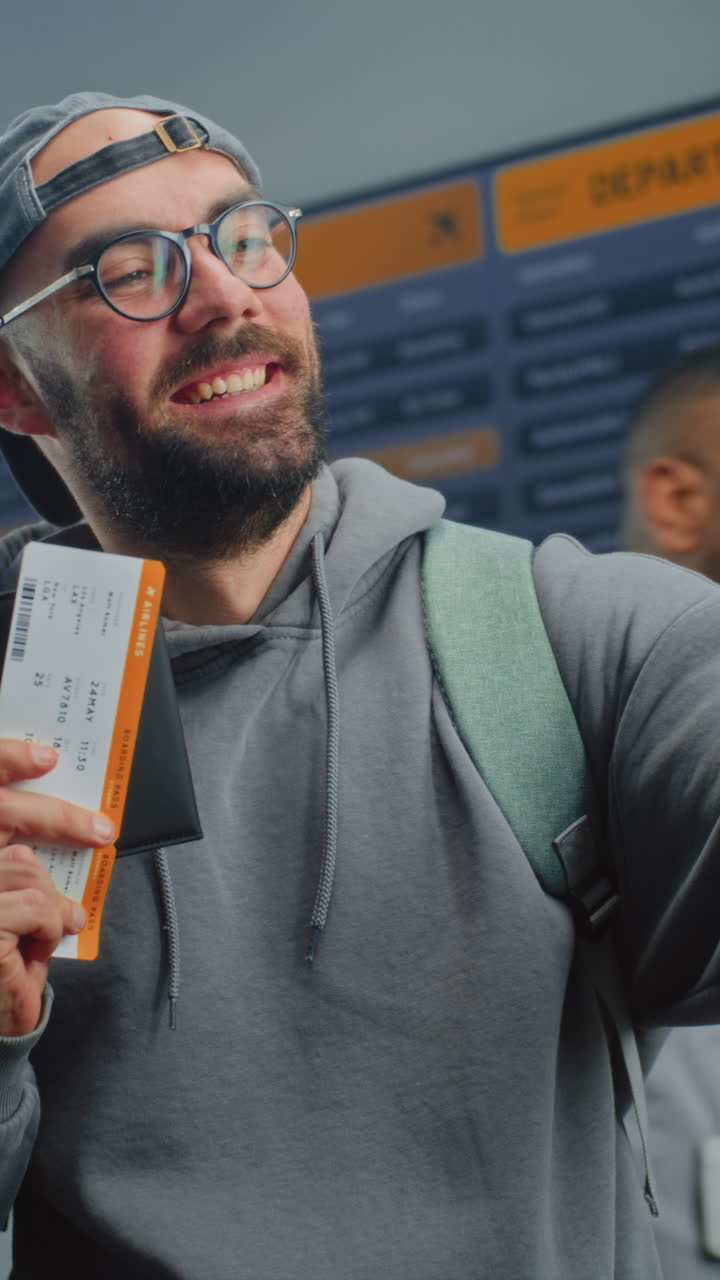 un hombre tomando una selfie en el aeropuerto con su tarjeta de embarque.
