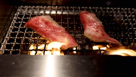 beef cooking on a flaming grill