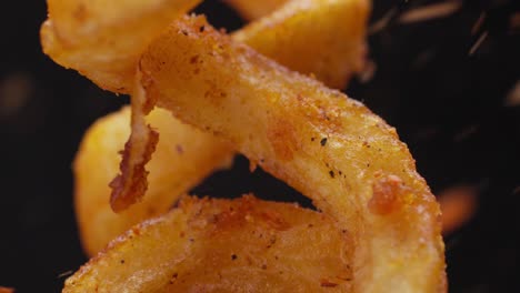 pouring chili powder on curly fries. junk food