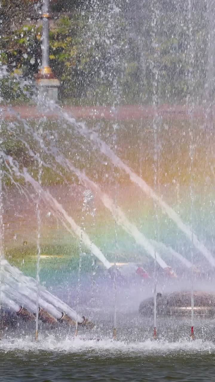 Colorful rainbow forms in fountain spray