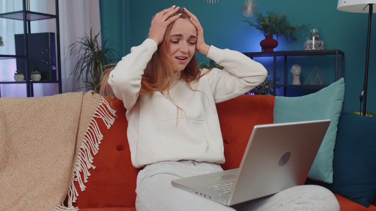 mujer joven usar computadora portátil en la habitación de casa, chica sorprendida por malas noticias, pérdida de fortuna, fracaso, resultados de la lotería