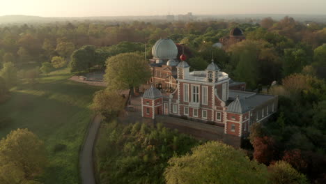 circling aerial shot of the greenwich observatory backlit at sunrise