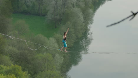 atleta cinematográfico en línea alta línea floja sobre el río en las altas montañas de alemania