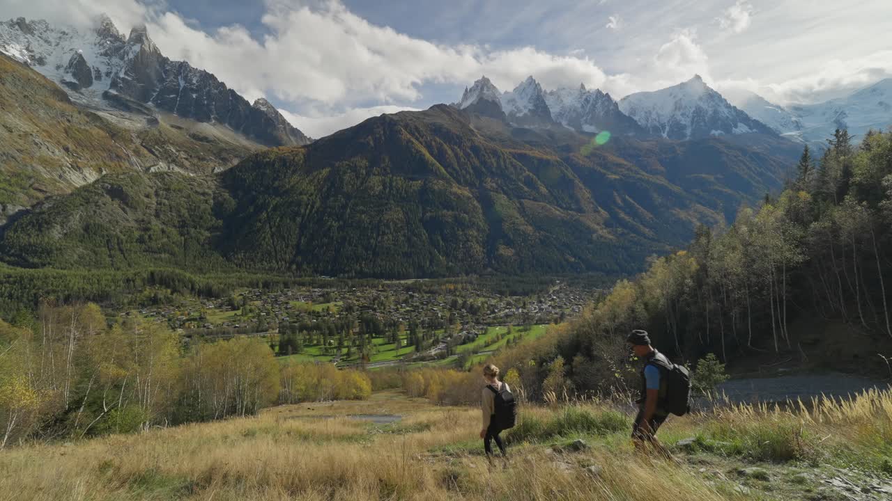 Coppia che scende nella valle con una vista mozzafiato su montagne e cime innevate