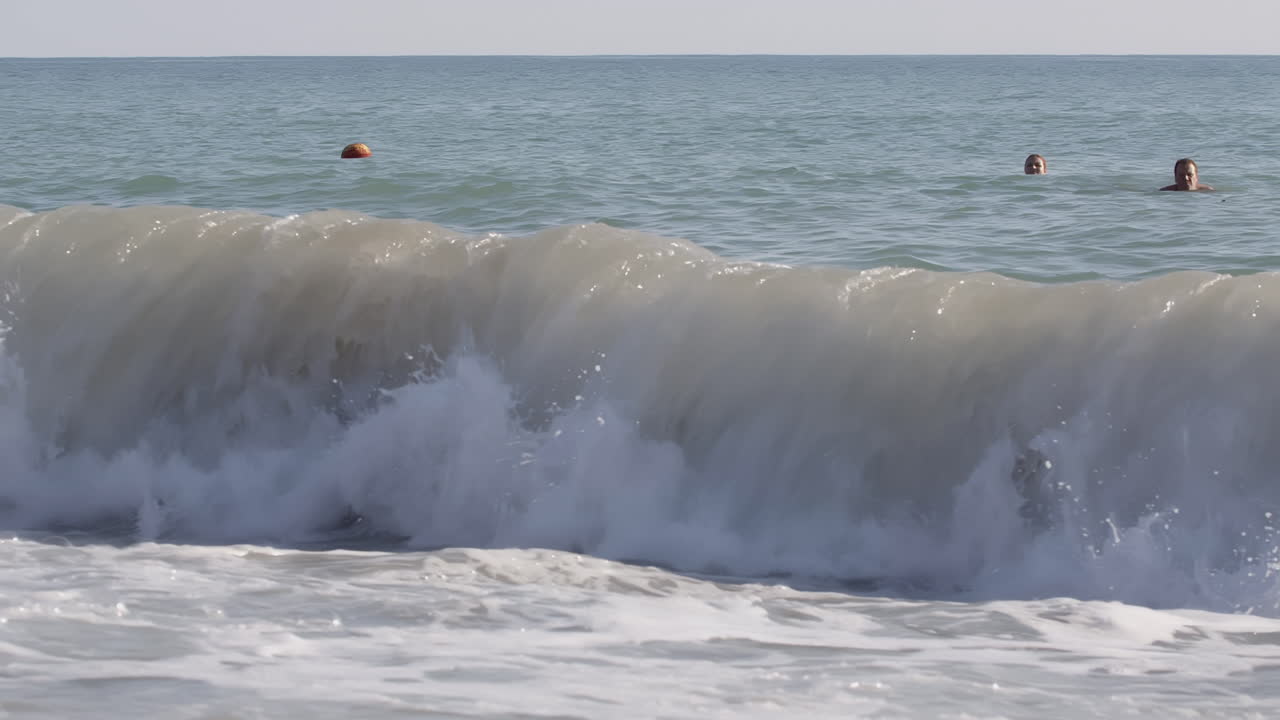 personas nadando en el océano con olas estrelladas