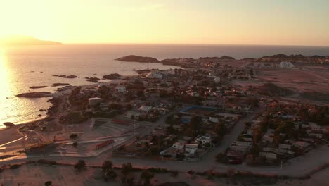 Vista-De-Pájaro-De-La-Ciudad-Costera-De-Bahía-Inglesa-En-La-Región-De-Coquimbo-Con-La-Puesta-De-Sol-Al-Fondo,-Chile