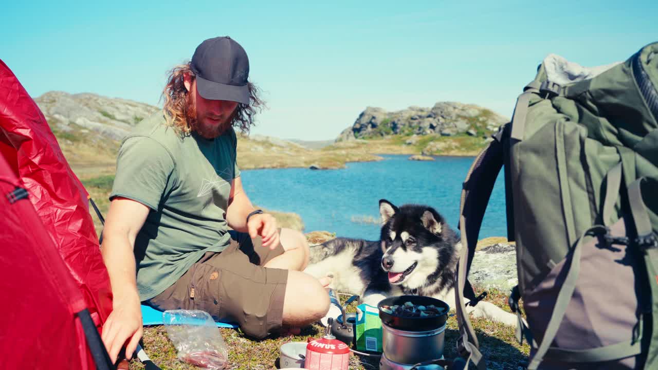 개 와 함께 앉아 음식을 준비 하는 남자 산책자 - 넓은
