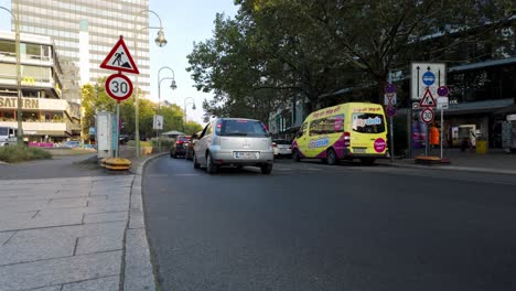cars stopping at traffic on city street in berlin, germany in daytime. wide shot
