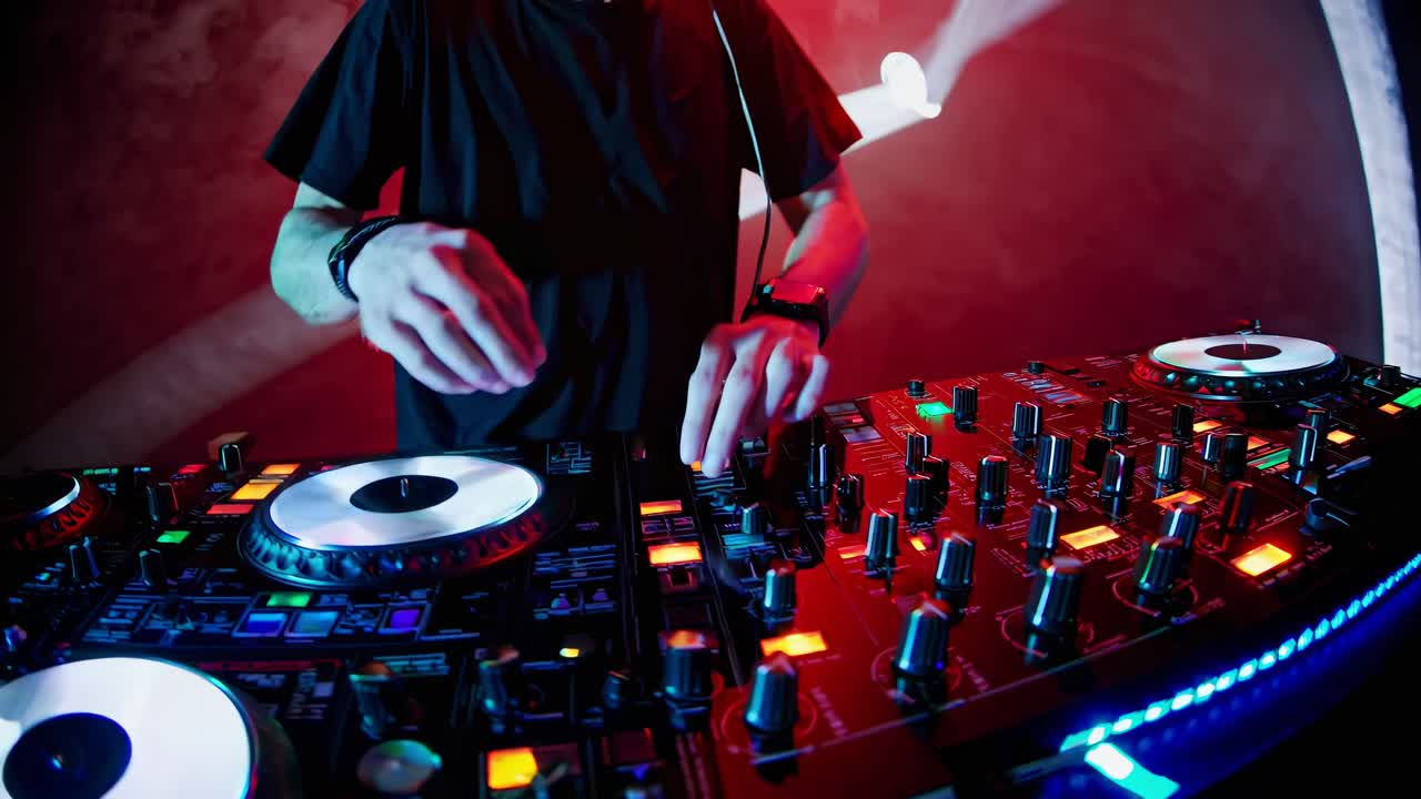 Low-angle shot of a DJ mixing tracks on a vibrant console, capturing the dynamic energy of a live