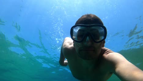 man swimming underwater in clear water