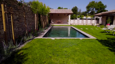aerial dolly shot revealing a tropical swimming pool in a villa garden