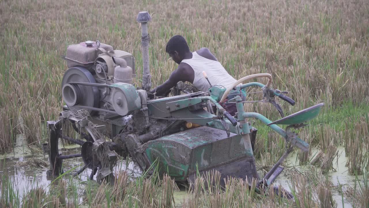 Farmer trying to start his harvester machine so that he can harvest his land.