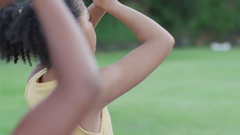 Mixed-race-schoolgirls-meditating,-doing-yoga-excersice-during-yoga-class-outdoors